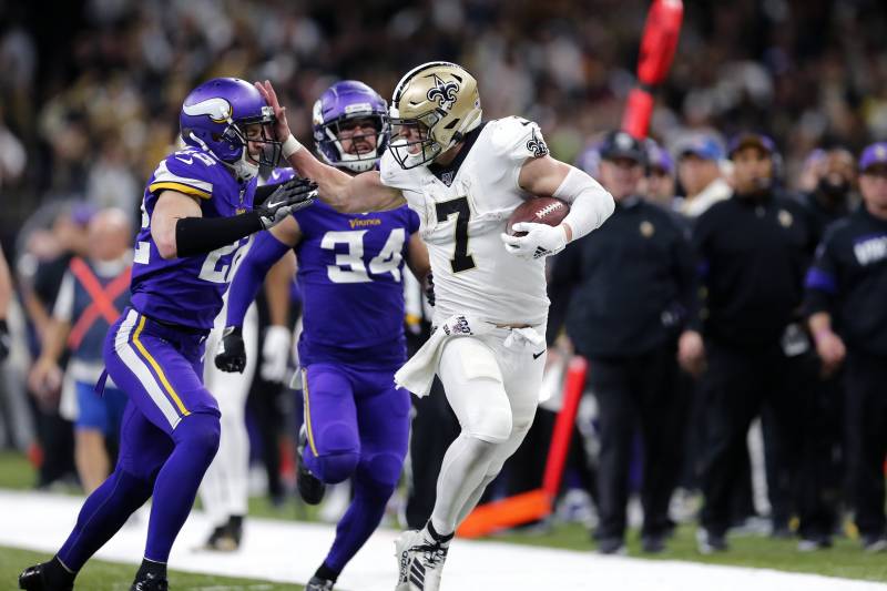 FILE - In this Sunday, Jan. 5, 2020, file photo, New Orleans Saints quarterback Taysom Hill (7) fends off Minnesota Vikings free safety Harrison Smith (22) on a long carry in the second half of an NFL wild-card playoff football game in New Orleans. The Saints have announced that dynamic reserve QB and utility player Taysom Hill has a new two year contract. (AP Photo/Brett Duke, File)